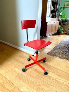 a red chair sitting on top of a hard wood floor