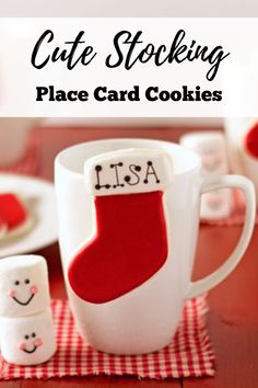 a red and white christmas stocking cookie sitting on top of a table next to a mug