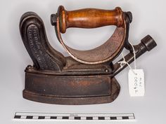 an old iron with a wooden handle on it and a price tag attached to it