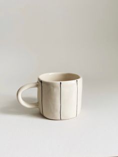 a white cup with black lines on it