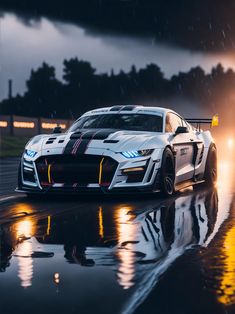 a white sports car driving down a wet road in the rain with its lights on