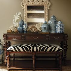 a zebra print bench with blue and white vases on it