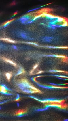 an abstract image of rainbow colored water ripples