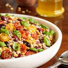 a white bowl filled with salad next to a glass of beer