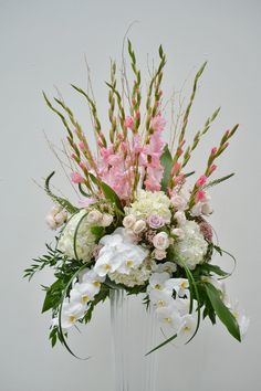 a vase filled with lots of white and pink flowers