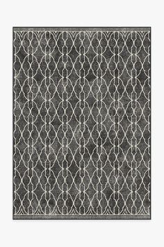 a black and white area rug with an intricate design on the bottom, in front of a gray background