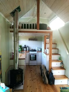 a small kitchen with stairs leading up to the top floor and an open loft above it