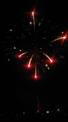 fireworks are lit up in the night sky with red and white lights on them,