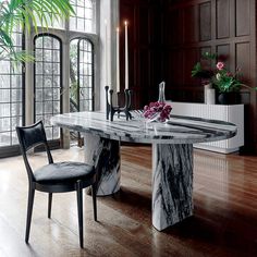 a marble dining table surrounded by two chairs