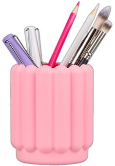 a pink cup filled with lots of different types of makeup brushes