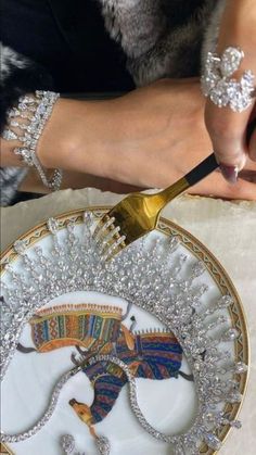 a plate with an elephant on it being cut by a woman holding a knife and fork