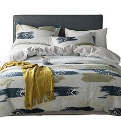 a bed with blue, white and yellow comforter on it's side next to pillows