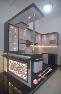 a man standing behind a counter in a kitchen