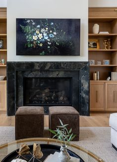 a living room filled with furniture and a painting on the wall above a fire place