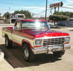 a red and brown truck parked in a parking lot next to a sign that says haysa