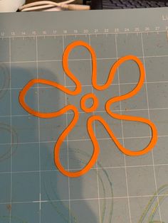 an orange flower cut out on top of a piece of paper next to a computer keyboard