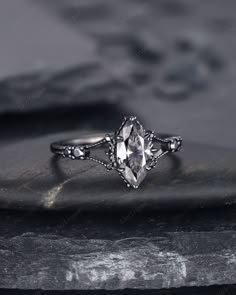 an antique style engagement ring on top of a rock