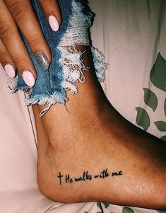 a woman's foot with the words, he walks with me tattooed on it