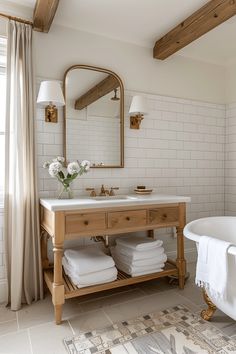 a bath room with a sink and a bath tub next to a large mirror on the wall