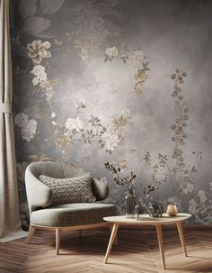 a chair and table in front of a wall with flowers on it