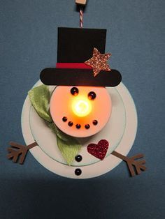 a white plate topped with a light up snowman on top of a blue wall