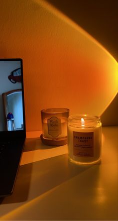 a laptop computer sitting on top of a desk next to a candle