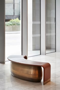 a bench sitting in the middle of a room next to large glass doors and windows