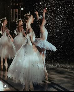 several ballerinas in white tutus and tiaras are dancing under falling snow