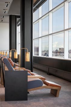 a row of chairs sitting next to each other in front of large windows