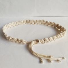 a white rope bracelet with an anchor on the end and a knot at the end