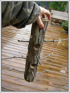 a person holding on to a wooden pole with nails stuck in the wood and nails sticking out of it