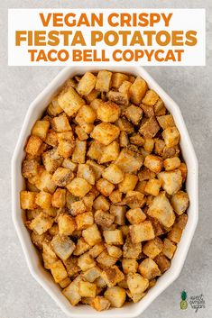 a white bowl filled with fried potatoes on top of a gray counter next to a sign that says vegan crispy fiesta potatoes taco bell copy