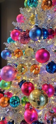 a brightly colored christmas tree decorated with ornaments