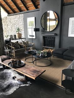 a living room filled with furniture and a large mirror on the wall above it's fireplace