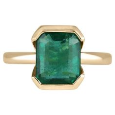 a gold ring with an emerald stone in the center