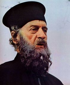 an old man with a long beard wearing a black outfit and a beret on his head