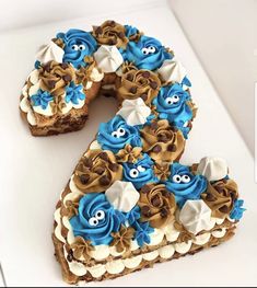 a cake shaped like the letter e with blue icing and white frosting on it