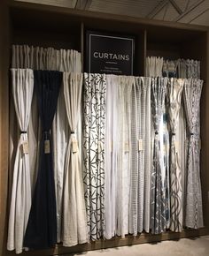 curtains are lined up on display in a store