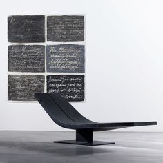 a chair sitting in front of a wall with writing on it