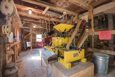 a large yellow machine sitting inside of a wooden building