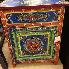 an ornately painted cabinet on display in a store