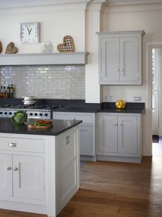 a kitchen with white cabinets and black counter tops