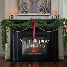 a fireplace decorated for christmas with greenery and candles