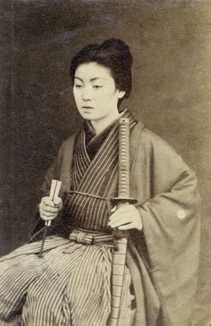 an old photo of a woman in traditional japanese dress