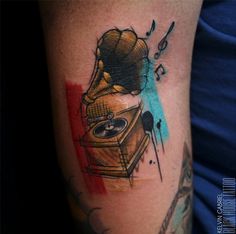 a tattoo on the arm of a man with an old record player and music notes