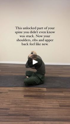 a woman sitting on top of a yoga mat in front of a wall with a quote