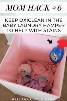 a pink container filled with baby laundry sitting on the floor