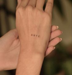 a woman's arm with the word arte tattooed on it, in black ink