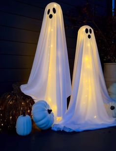 two white ghost statues sitting on top of a table