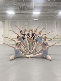 a group of ballerinas standing in a circle together